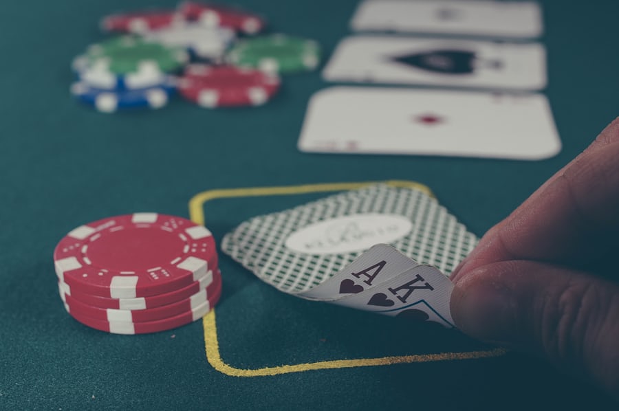 Tangan memegang kartu as dan raja sekop di meja poker